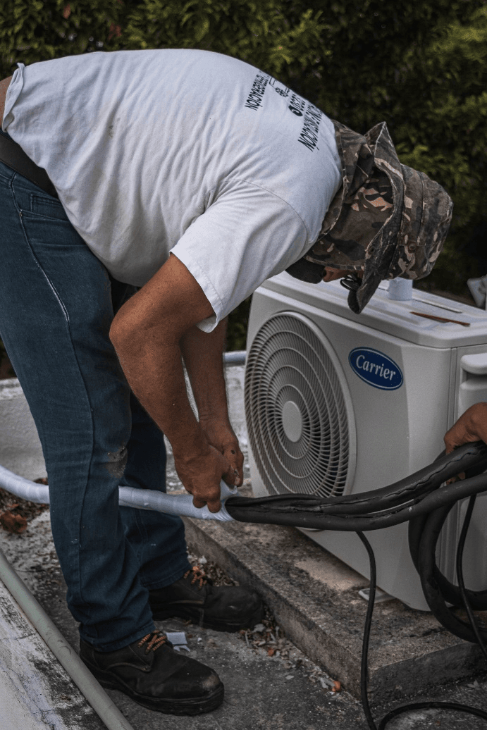 a man taping an AC's hose 